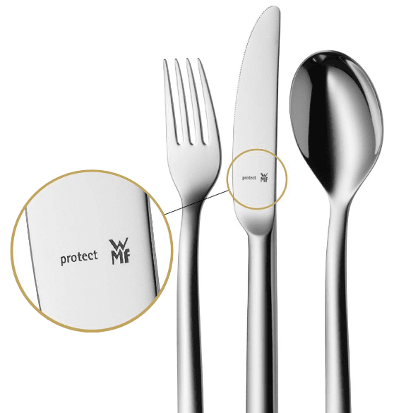 Ein Messer, eine Gabel und ein Löffel vor weißem Hintergrund. Das "WMF protect" Aufschrift auf dem WMF Messer wird in einem Kreis neben dem Besteck vergrößert.