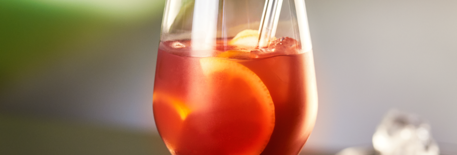 Rotes Getränk im Weinglas mit Orangen