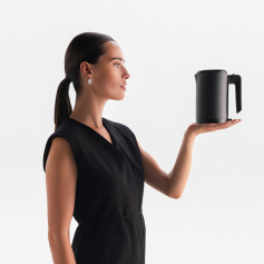 Frau mit Zopf hält einen WMF Küchenminis wasserkocher in der Hand