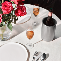 Gedeckter Tisch mit Rosenstrauss Sektkühler und Sektgläsern